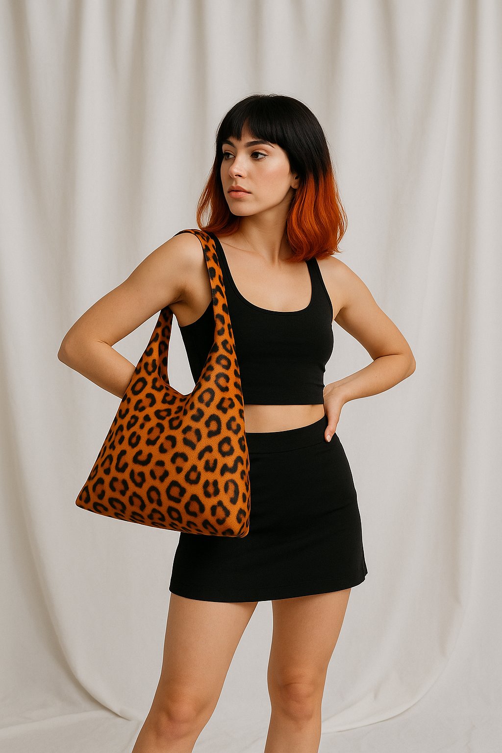 red genuine leather shoulder bag with gold chain strap on a light pedestal