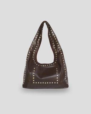Brown leather handbag with silver studs on a light gray background