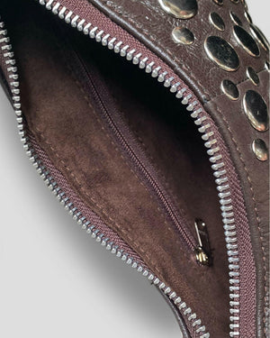Close-up of a brown leather clutch with silver studs and zipper