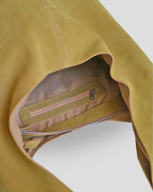 Close-up of a brown suede shoulder bag with a zipper pocket