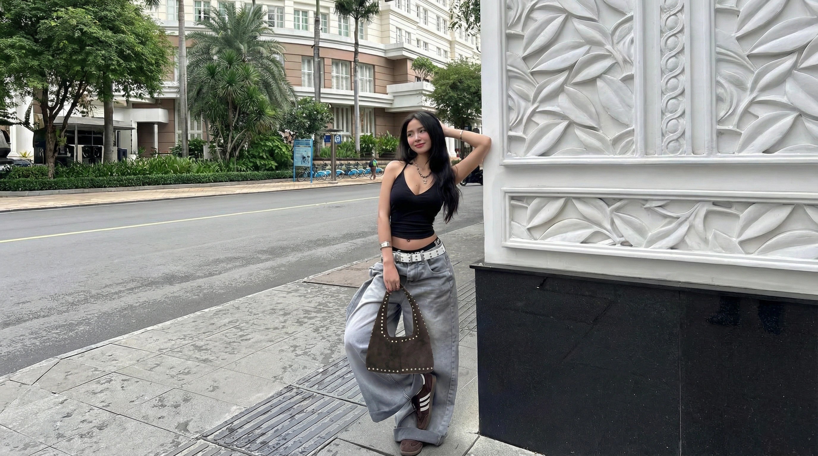 Woman standing on a sidewalk with suede bag by nam leather bali