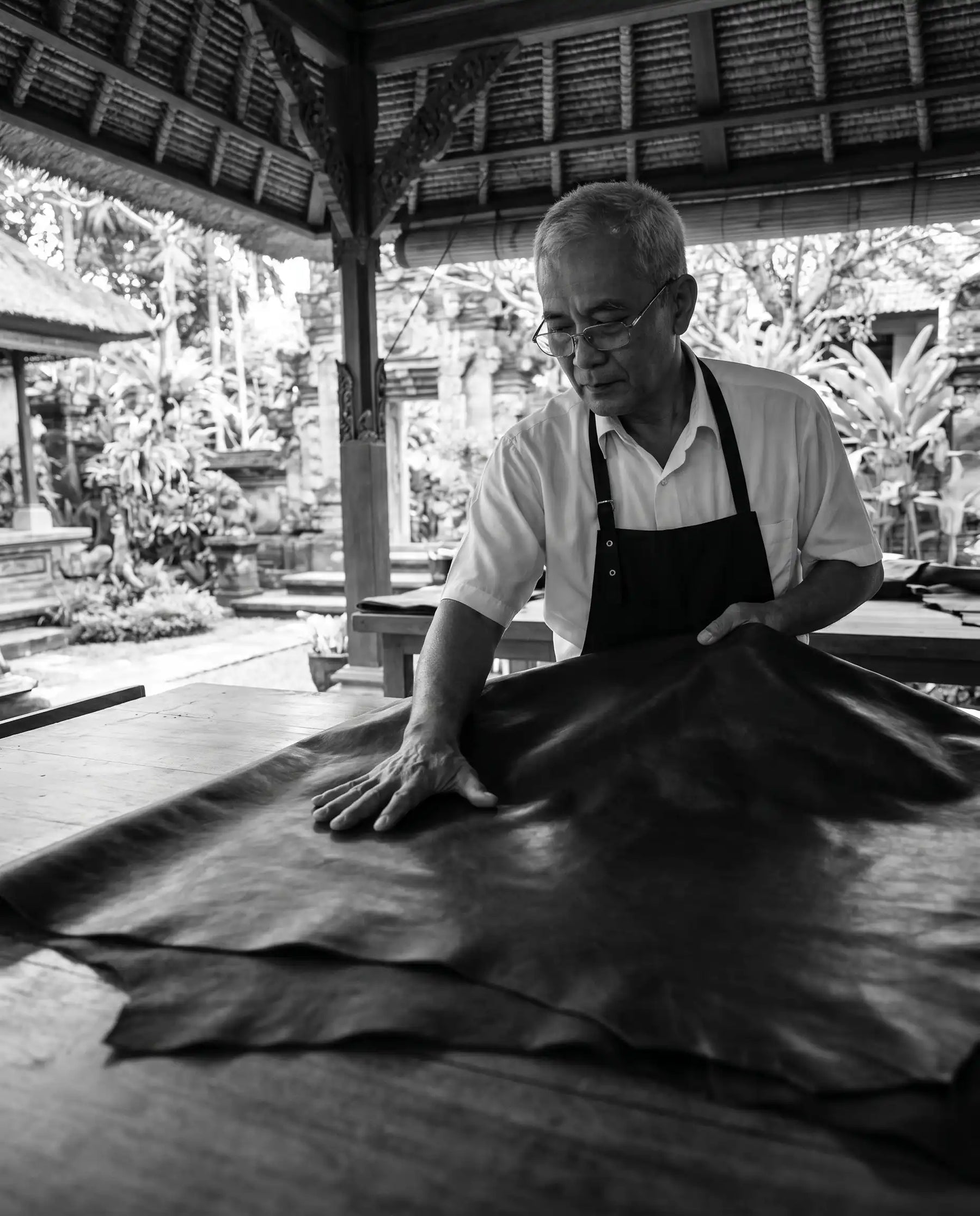 Balinese leather artisan handcrafting genuine leather bag in Namleather workshop in Bali