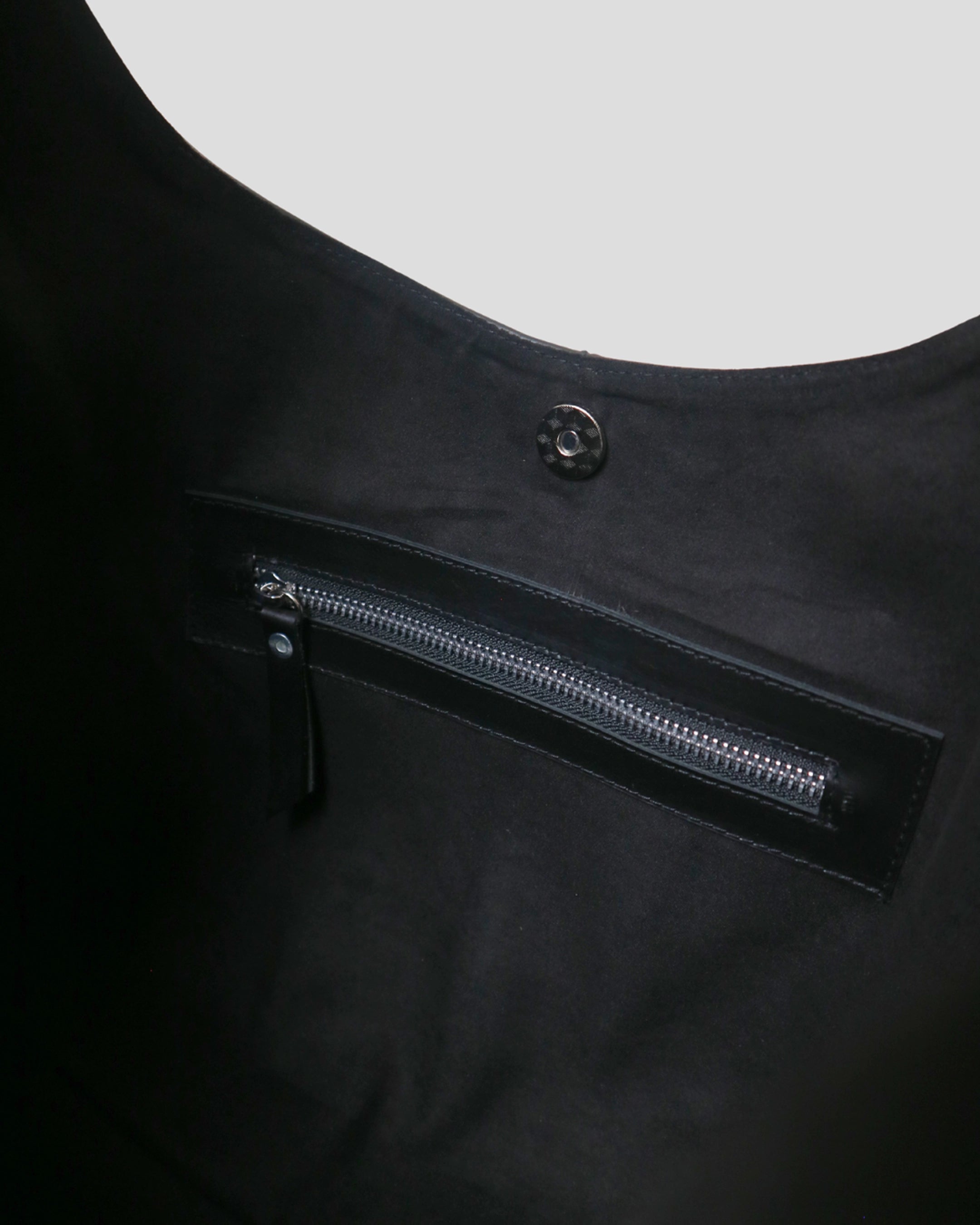 Interior zipper pocket of Kaia Plain women leather bag in black – magnetic closure and organized compartment