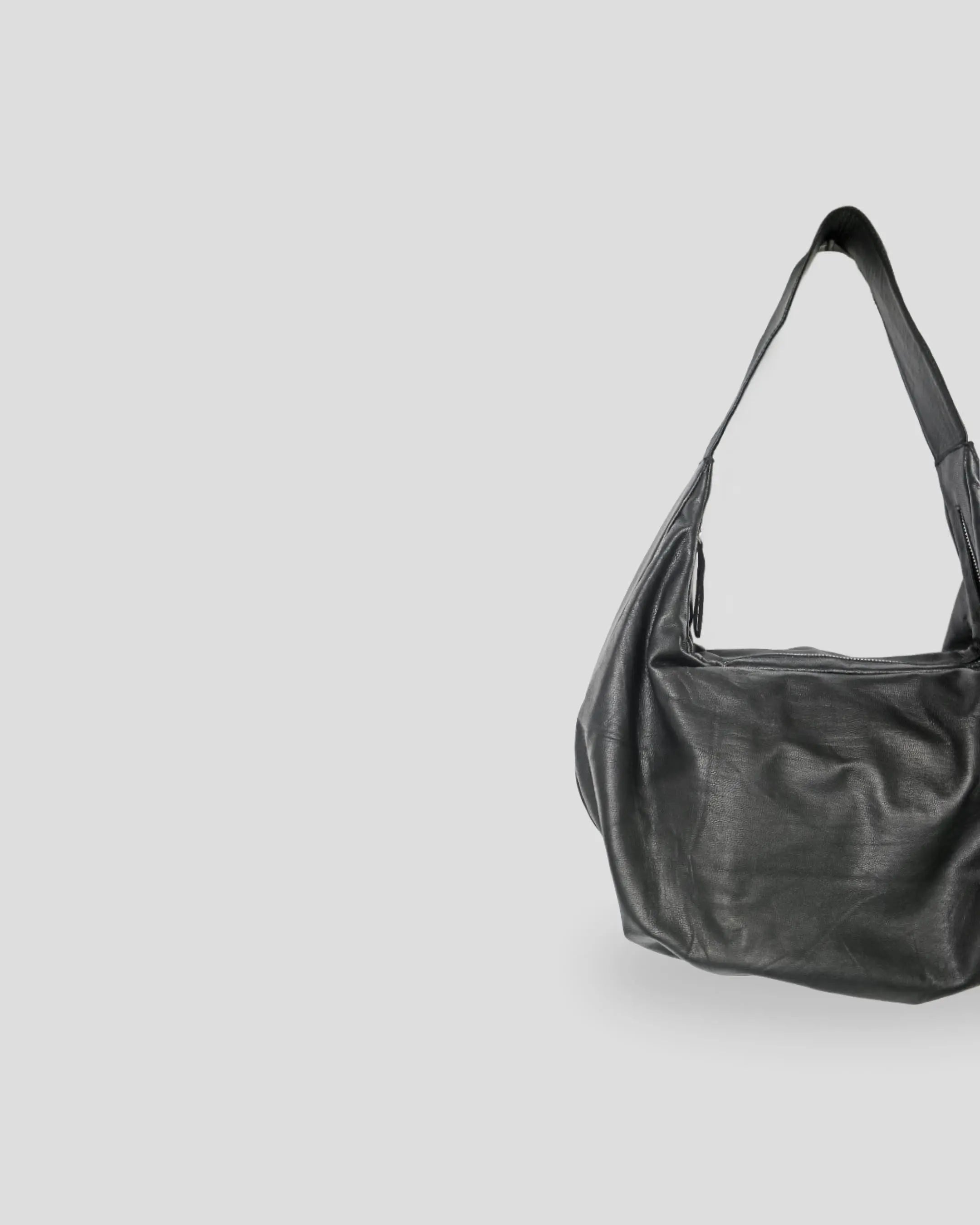 Black leather handbag on a light gray background