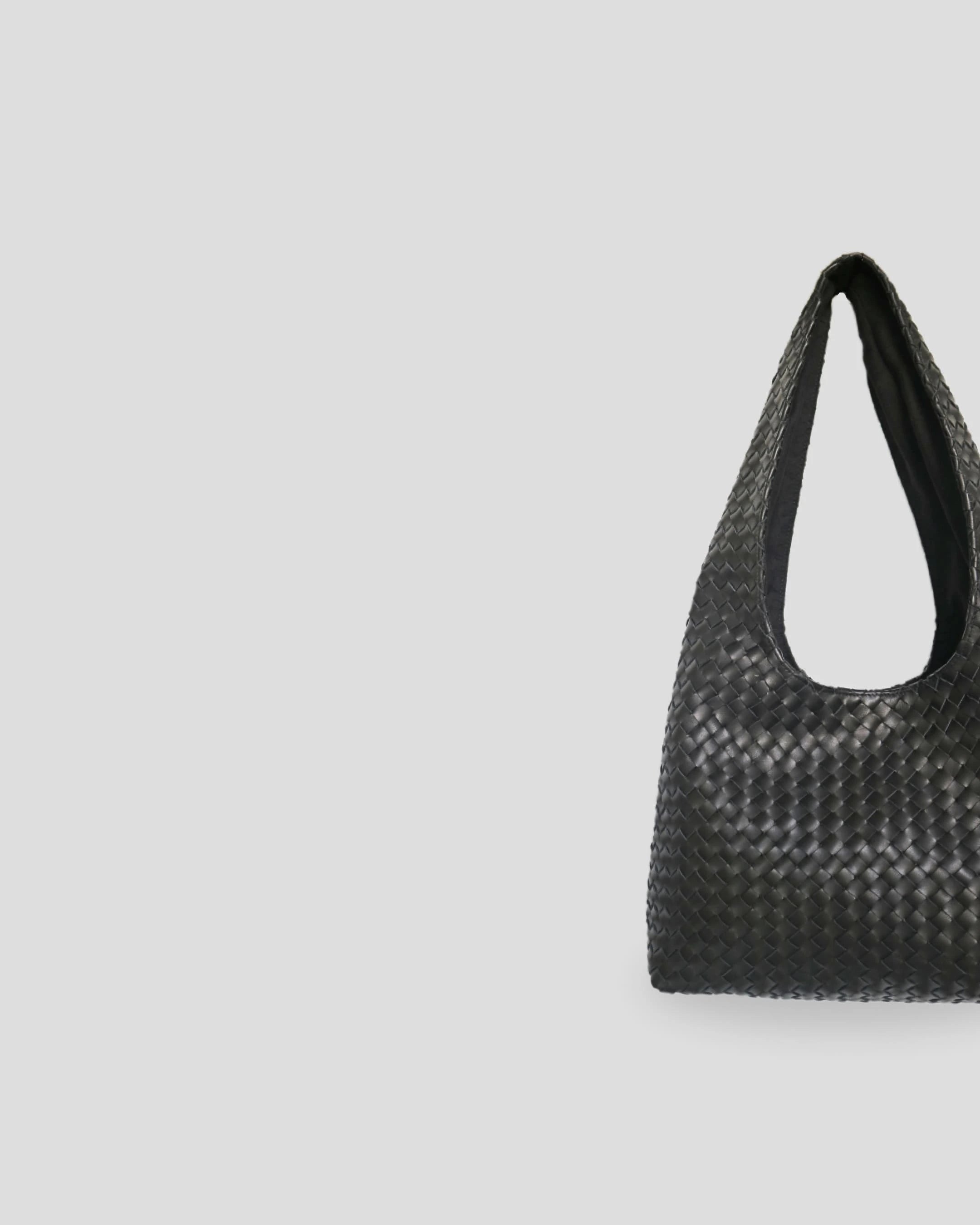 Close-up view of woven leather texture on women's shoulder bag showing detailed braided pattern and craftsmanship