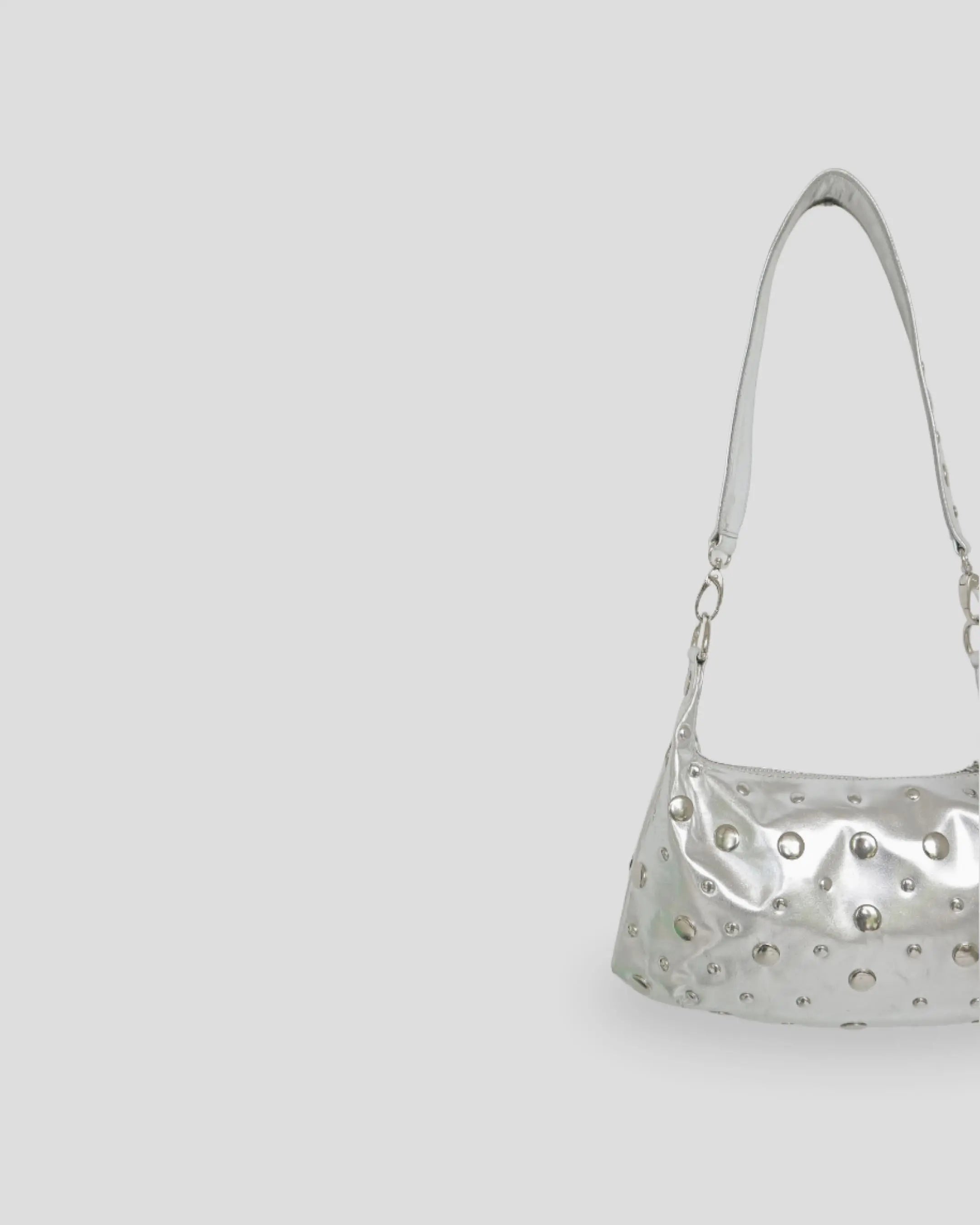 Silver handbag with studs on a light gray background
