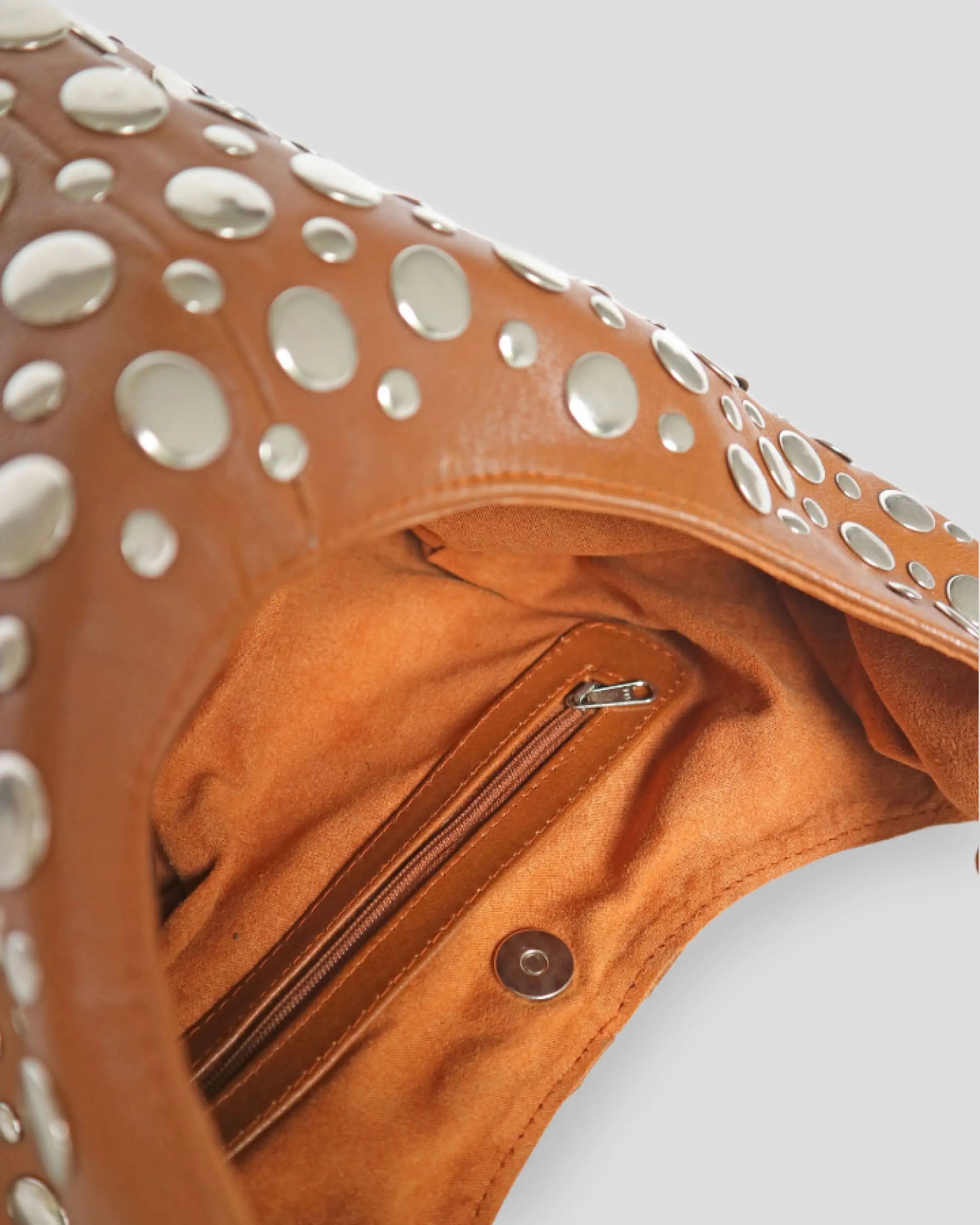 Side angle of handmade studded leather shoulder bag showing spacious interior and stylish silhouette for women
