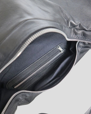 Interior view of women's shoulder bag showing zipper pocket and suede lining details