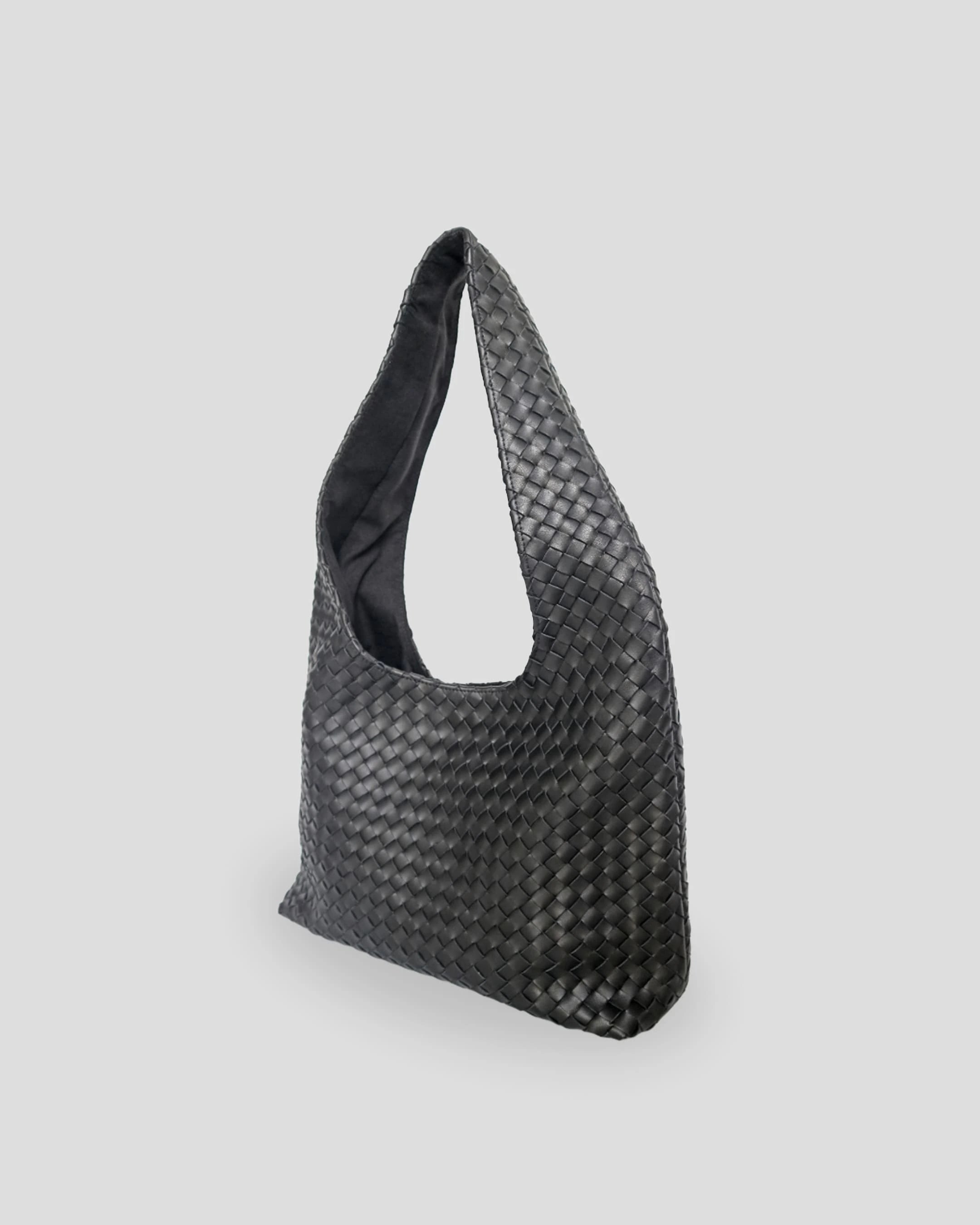  Side angle of handmade woven leather shoulder bag showing depth and spacious interior capacity for women