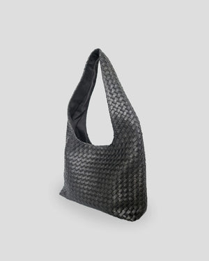  Side angle of handmade woven leather shoulder bag showing depth and spacious interior capacity for women